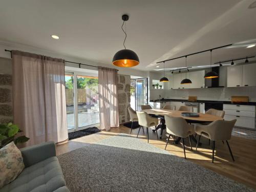 een woonkamer en een keuken met een tafel en stoelen bij Casa Lage da Pena in Geres