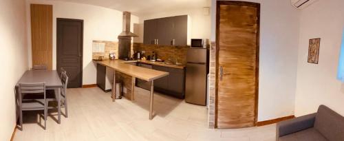 リュクシアナにあるLa parenthèseの木製のテーブルと冷蔵庫のあるキッチン