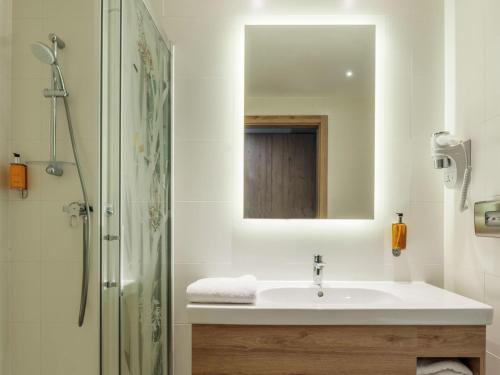 a bathroom with a sink and a shower with a mirror at ibis Styles Kraków East in Kraków
