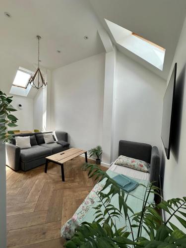 a living room with a couch and a table at The garden house, separate entrance, free parking in Mitcham