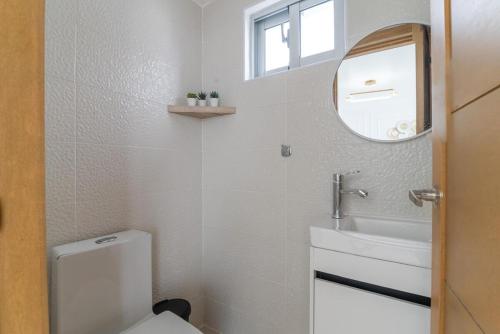 a bathroom with a toilet and a sink and a mirror at Casa Luma Vistacana in Pueblo Bavaro