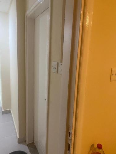 a room with a white door and a yellow wall at Luxuries Private Room In a Home In Front of Mega Mall Sharjah in Sharjah
