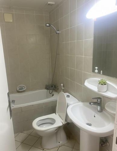 a bathroom with a white toilet and a sink at Luxuries Private Room In a Home In Front of Mega Mall Sharjah in Sharjah