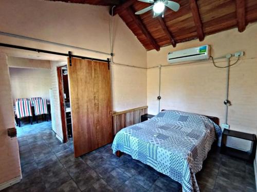 El Mangrullo في فيديراسيون: غرفة نوم بها سرير ومروحة سقف