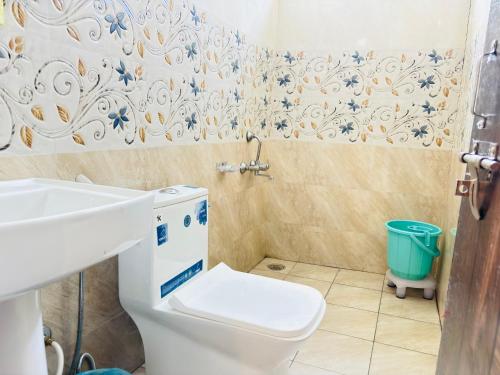 un baño con inodoro y lavabo en Aroha home stay, en Pālampur