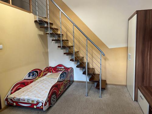 a bedroom with a car bed next to a staircase at Apartament LUX Franciszkańska, Przemyśl in Przemyśl