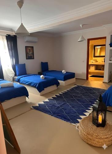 a bedroom with two beds and a blue rug at Villa Léa in Marrakesh