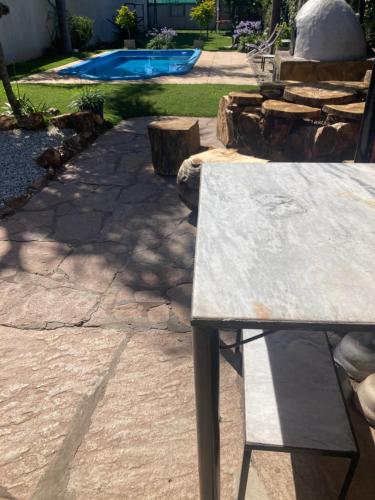Quinta Hostaco في سان نيكولاس دي لوس أرويوس: مقعد موضوع في فناء به مسبح