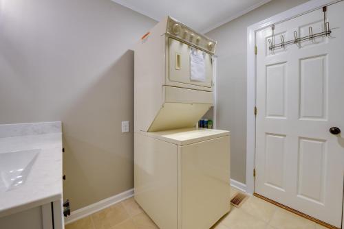 Sweet Southern Pines Abode with Yard and Covered Porch في سوثيرن باينس: وجود ثلاجة بيضاء في مطبخ بجانب باب