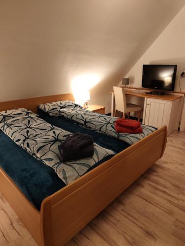a bedroom with a bed and a desk with a television at Endes Dreiseithof - Apartment in Schliengen