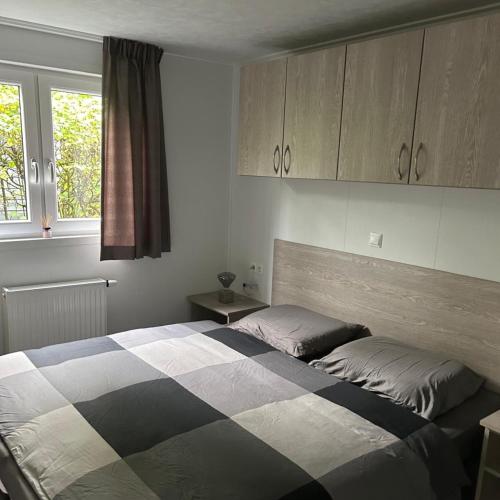 a bedroom with a bed and cabinets and a window at Luxus Chalet Time Out De Veerstal in Lathum