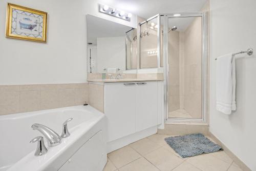 a bathroom with a tub and a sink and a shower at Luxurious 2BD Condo with Direct Ocean Views & Resort Pool in Sunny Isles in Sunny Isles Beach