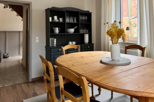 een eetkamer met een houten tafel en stoelen bij Das Winzereck - 4 Sterne Ferienhaus in der Südpfalz in Ranschbach