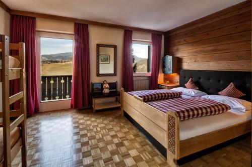 um quarto com uma cama e uma grande janela em Solaia Hotel & Guesthouse em Castelrotto