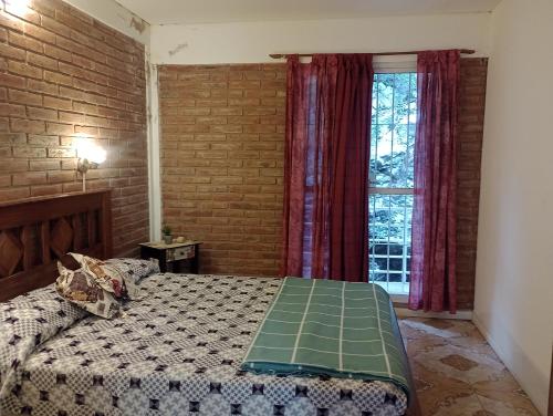 a bedroom with a bed and a brick wall at Cabañas Sprinter in Trapiche