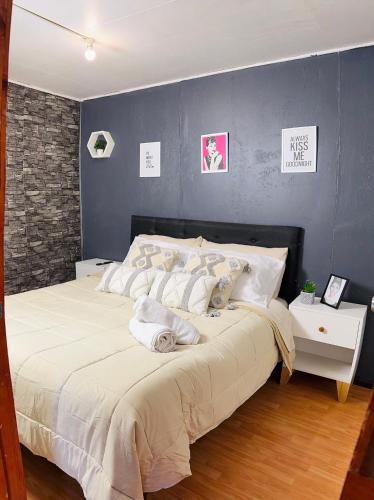 a bedroom with a large bed with a blue wall at Minidepto temuco in Temuco