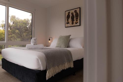 a bedroom with a large white bed with a window at Gull's Whisper - all you need in Falmouth