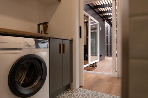 a washing machine in a room with a hallway at Gull's Whisper - all you need in Falmouth
