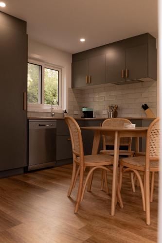 a kitchen with a wooden table and chairs at Gull's Whisper - all you need in Falmouth