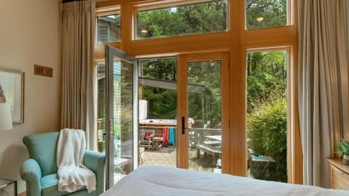 a bedroom with a bed and a sliding glass door at The Castle Rock Estate by AvantStay Steps From Arch Cape beach w Hot Tub Sauna in Arch Cape