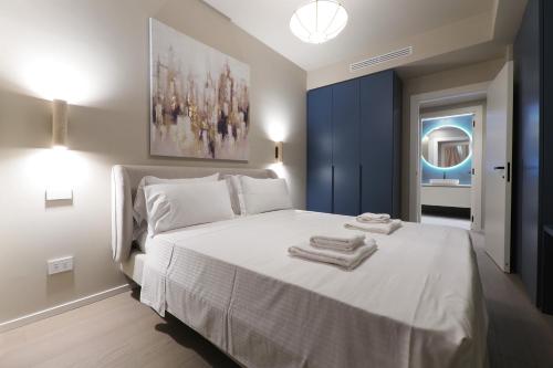 une chambre avec un lit blanc avec des serviettes dessus dans l'établissement Duomo Luxury Apartment XII, à Milan