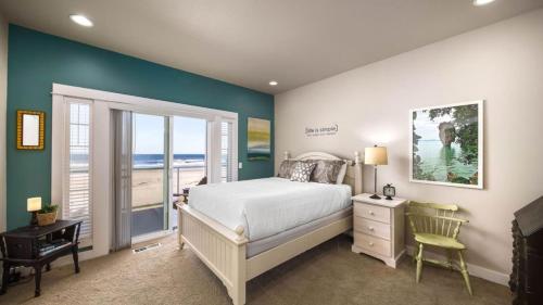 a bedroom with a bed and a view of the ocean at Moonlight by AvantStay Modern Home w Views Direct Access to Rockaway Beach in Rockaway Beach