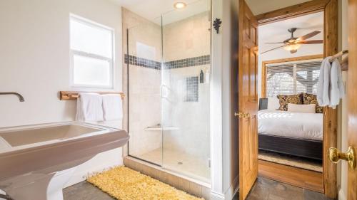 a bathroom with a tub and a glass shower at Hot Tub Fire Pit Game Room Large Deck Views Angels Camp Lodge by AvantStay in Big Bear Lake