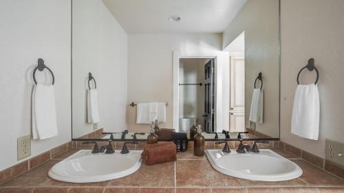 a bathroom with two sinks and a large mirror at Marillac by AvantStay Gorgeous Ski Cabin w Balcony Patio in Olympic Valley