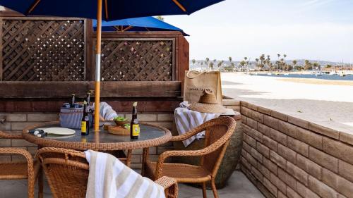 a table and chairs with an umbrella on the beach at Bay View II by AvantStay Ocean View Mission Beach Home on the Sand in San Diego