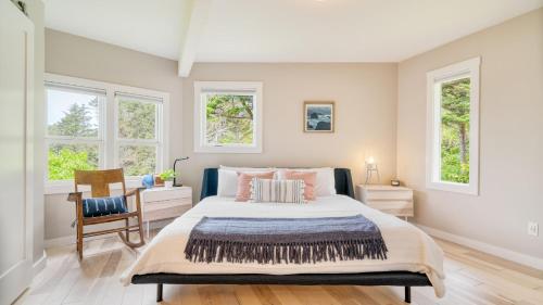 a bedroom with a large bed and two windows at Sunset Cove by AvantStay Beachfront w Balcony in Arch Cape