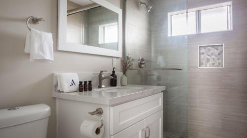 a white bathroom with a sink and a shower at Seashore VII by AvantStay Modern La Jolla Flat 5mins from the Beach in San Diego