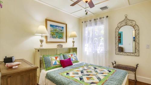 un dormitorio con una cama y un espejo en Paradise Palms by AvantStay Great Location w Outdoor Dining BBQ Close to Higgs Beach Month Long Stays, en Key West