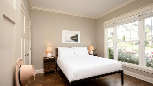 a bedroom with a white bed and a window at Sweetgum by AvantStay Black Mountain Retreat w Covered Deck in Black Mountain