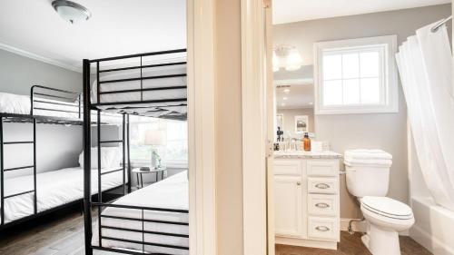 a bedroom with bunk beds and a bathroom with a toilet at Sweetgum by AvantStay Black Mountain Retreat w Covered Deck in Black Mountain