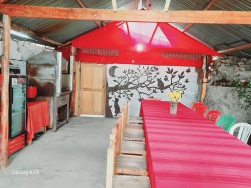 a red table with a red carpet in a room at Casa Corazao in Urubamba