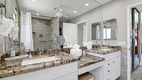 a bathroom with two sinks and a large mirror at Ranch Oasis w Private Pool HotTub Firepit Mountain Views Gobi by AvantStay in Palm Springs