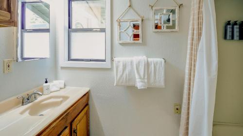 a white bathroom with a sink and a shower at Aster by AvantStay Classic Kings Beach Cottage In The Of North Shore in Kings Beach