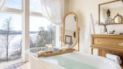 a bathroom with a tub and a large window at River House by AvantStay Historic Secluded Estate on the Hudson River w Pool Sleeps 24 in Hudson