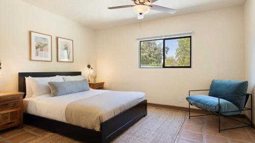 a bedroom with a bed and a fan and a chair at Sleeps 20 Architectural Mansion w Pool Indoor Tennis Court Game Room Starlight Estate by AvantStay in Bermuda Dunes