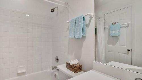 a white bathroom with a white tub and a toilet at Key West Found by AvantStay Close to Shops w Patio Shared Pool Week Long Stays Only in Key West
