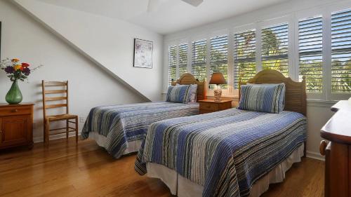 a bedroom with two beds and a staircase with windows at Key West Found by AvantStay Close to Shops w Patio Shared Pool Week Long Stays Only in Key West