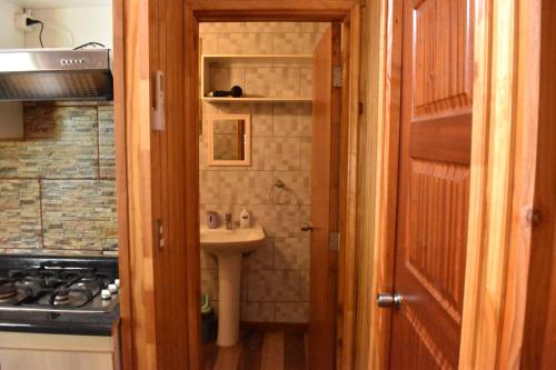 Baño pequeño con lavabo y lavabo en Cabañas Mister Nelson, en Valdivia