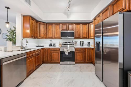 Luxury Condo Retreat in Merritt Island RFI-1004 في Audubon: مطبخ مع خزائن خشبية وأجهزة من الفولاذ المقاوم للصدأ