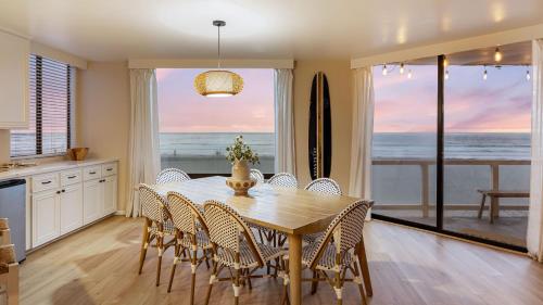 a dining room with a table and chairs with a view of the ocean at Beachfront Home w Ocean Views • Right on Mission Beach Belmont by AvantStay in San Diego