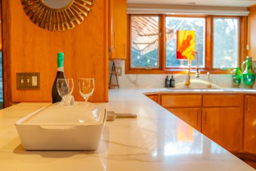 Country Stay 6 Min to Town with Deck & Jetted Tub في لورانس: مطبخ مع زجاجة من النبيذ وكؤوس على منضدة