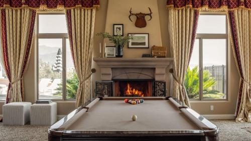 a pool table in a living room with a fireplace at Sangiovese By AvantStay Spectacular Estate w Pool Hot Tub Putting Green in Temecula