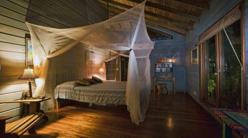 un dormitorio con una cama con mosquitera en Fuego Del Mar Oceanfront Luxury Villa on Private Estate, en Juticalpa