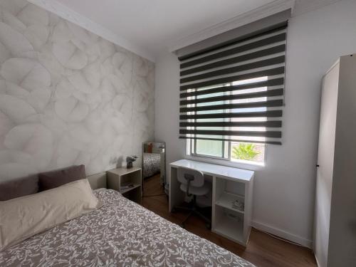 a bedroom with a bed and a window with a desk at Room Mayi GC in Las Palmas de Gran Canaria