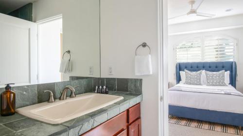 a bathroom with a sink and a bed at Villa Verbena by AvantStay Expansive Estate w B-ball Court PoolSpa Entertainers Yard in Bermuda Dunes