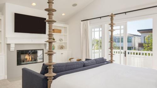 um quarto com uma cama e uma lareira em Emerald Cove by AvantStay Mins to Beach Pier em Newport Beach